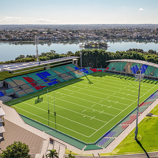 A 3D rendering of an upgraded suburban rugby league ground set on a harbour